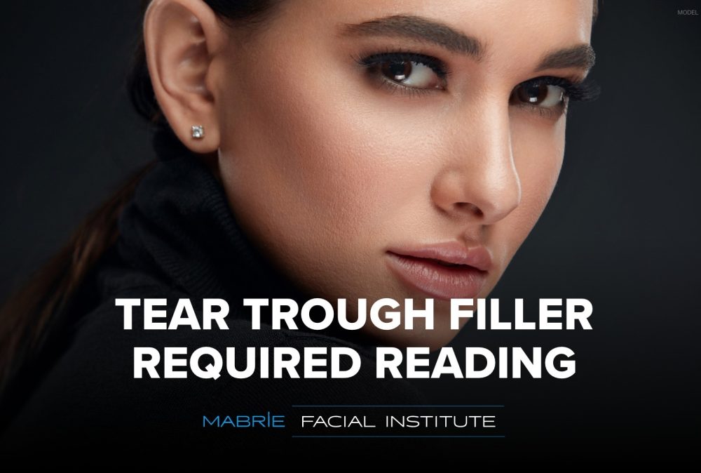 Woman looking fiercely over her shoulder (model) with text that reads 'Tear Trough Filler Required Reading'